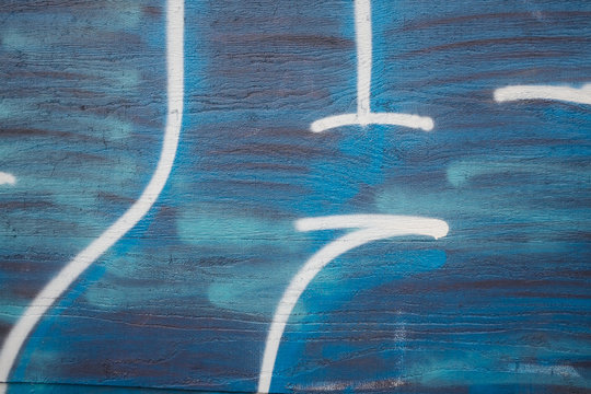 Graffiti tag and spray paint in building wall, close up