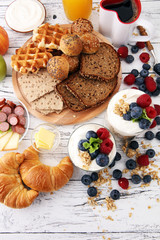 Obraz na płótnie Canvas Breakfast served with coffee, orange juice, bread, parfaits and fruits. Balanced diet