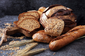 Sliced rye bread on cutting board. Whole grain rye bread and rolls with seeds.