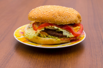 Delicious hamburger or sandwich on plate on wooden table