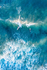 Beautiful beach, coast and bay with crystal clear sea water and surfers seen from above