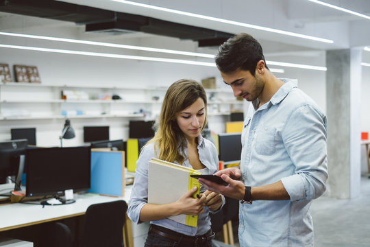 Young People Using Tablet Computer At Work