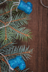Christmas composition. Fir branches, blue Christmas decorations on a wooden brown background. Space for text, top view. Background