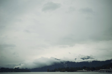 Paisaje invernal suizo con las montañas de Los Alpes cubiertas de niebla densa blanca.