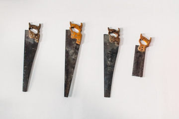 four old saws on a white wall