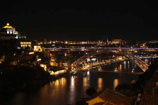Illuminated embankment at the riverside with nice old European architecture at the night time