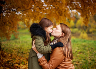 Fototapeta premium Happy family mother and child little daughter playing on autumn walk. Happy family. The school holidays.