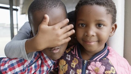 Children from South African community looking at camera & pulling faces
