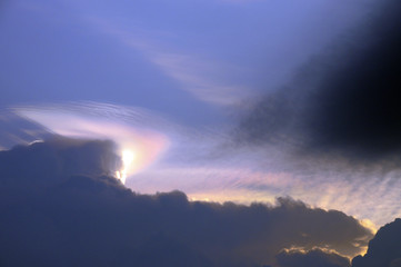 Fototapeta na wymiar Rainbow and clouds in sky at sunset