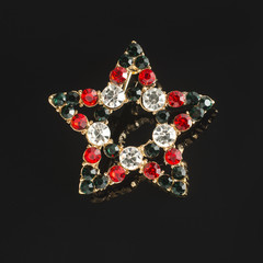 star brooch with diamonds isolated on black