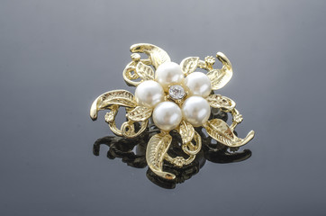 gold brooch flower with pearl isolated on black