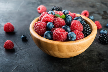 Fresh berries in a bowl on dark  background close up