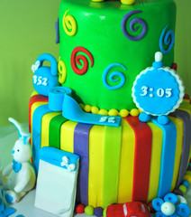 Closeup of cake on a children's holiday in the background.
