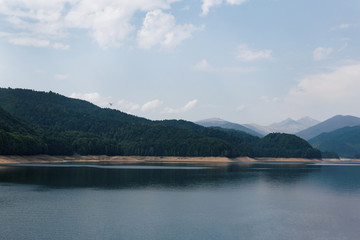White drone flying over Lake Vidraru at Fagaras Mountains. Romania