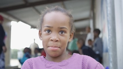 Little girl from a South African community looking inquisitively at the camera