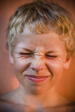 Little Blonde Boy Eating Something Sour