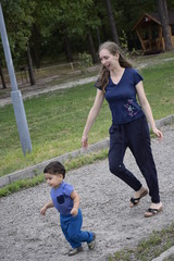 мать с ребенком бегают по дорожке в парке 