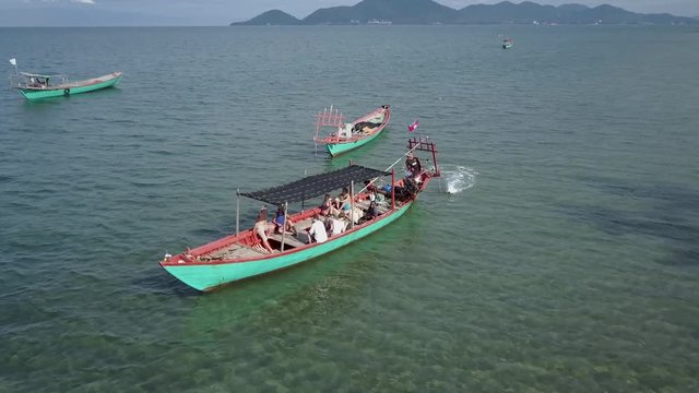 Tourist boat owned by a fisherman, loaded with backpackers, goes out for snorkeling in the waters around Rabbit Island, Koh Tonsay, Cambodia.