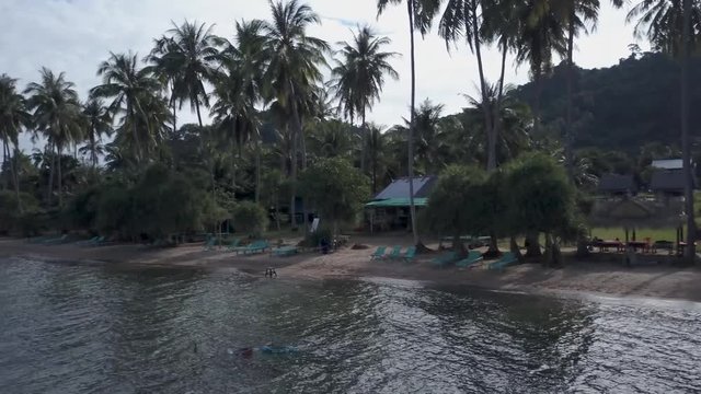 Camera pans across the beach of Koh Tonsay, Rabbit Island, Kep Province, Cambodia in the morning light.