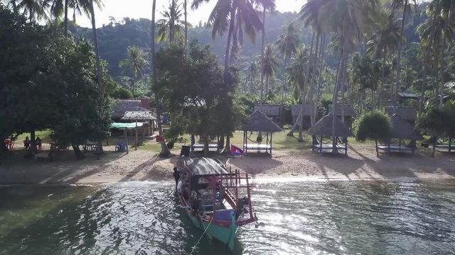 Backpacker tourists board a fisherman&rsquo;s boat as they prepare to go snorkeling in the waters around Koh Tonsay, Rabbit Island.