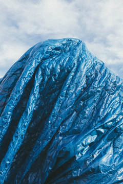 Blue tarpaulin covering pile of commercial fishing equipment