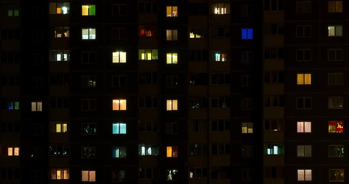 Light in the windows of a multistory building. Time lapse  