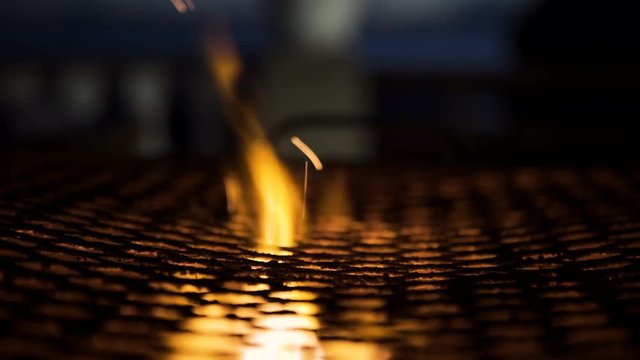  Close up flames flickering on barbecue cooker at beach hotel at night