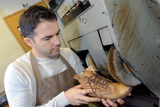 shoemaker repairs shoes in the studio craft grinder machine