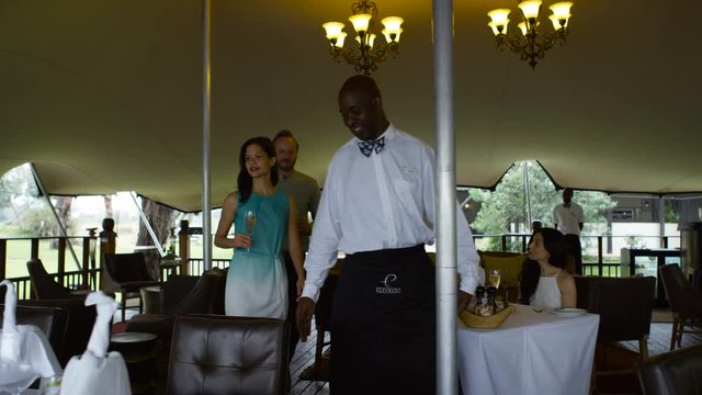  Happy couple on vacation taking their seats for dinner in elegant restaurant