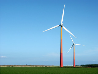 Two modern windmills in a Dutch Landscape against clear blue sky