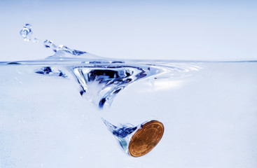 Making a Wish by throwing a Coin in a Wishing Well, water splashing up. focus on the Money