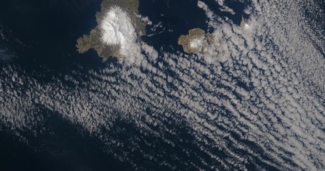 Very high-altitude overflight aerial of several of the smaller Aleutian Islands . Clip loops and is reversible. Elements of this image furnished by USGS/NASA Landsat