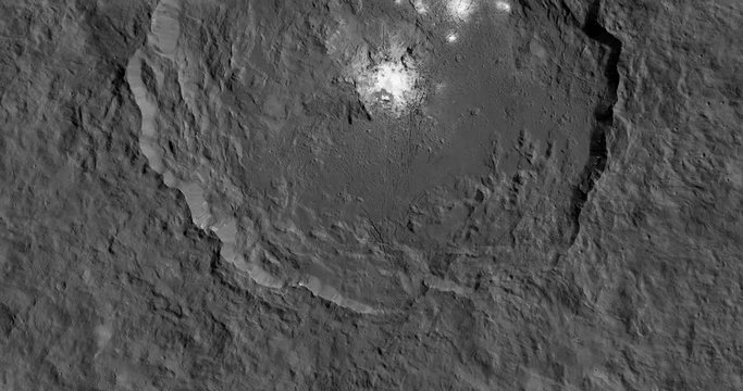 Very high-altitude overflight aerial of Occator Crater's white spots, Ceres . Clip loops and is reversible. Elements of this image furnished by JPL/NASA