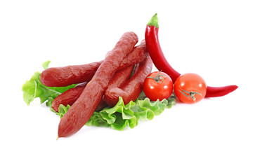 Composition with delicious smoked sausages and vegetables on white background