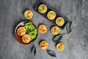 Composition with broccoli quiche tartlets on table