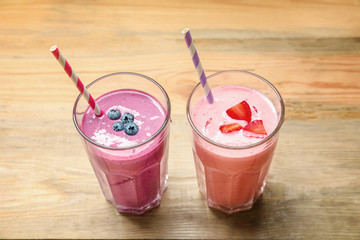 Glasses with yummy smoothie on wooden table