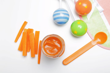 Composition with tasty baby food in jar on white background