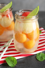 Jar of delicious cocktail with melon balls on table