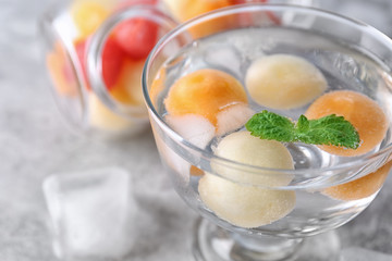 Glass of delicious cocktail with melon balls, close up