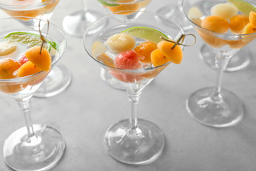 Glasses of delicious cocktails with melon balls on table