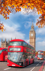 Naklejka na ściany i meble Buses with autumn leaves against Big Ben in London, England, UK