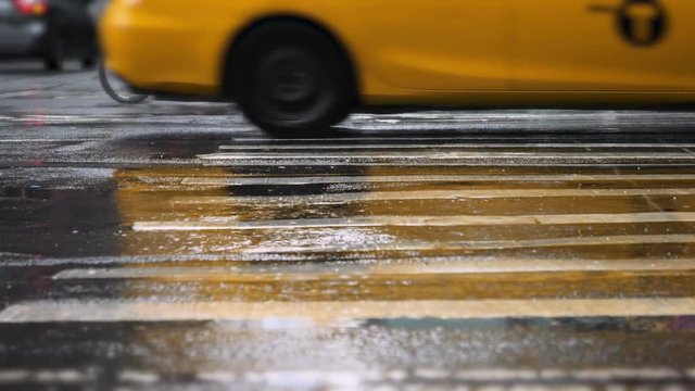 A low angle slow motion view of traffic on a rainy Manhattan street.  	
