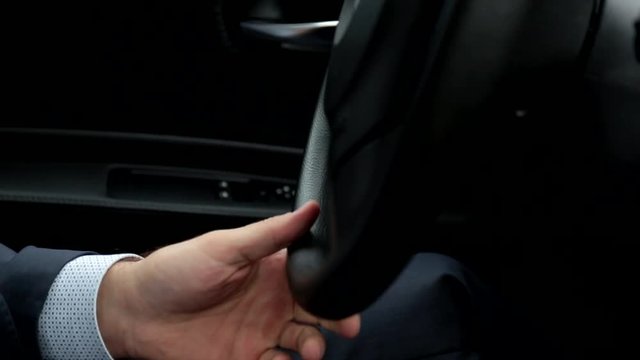 Respectable, responsible man driving car. Raining day. Dangerous road. The man in a suit. the man holds the steering wheel. Close up