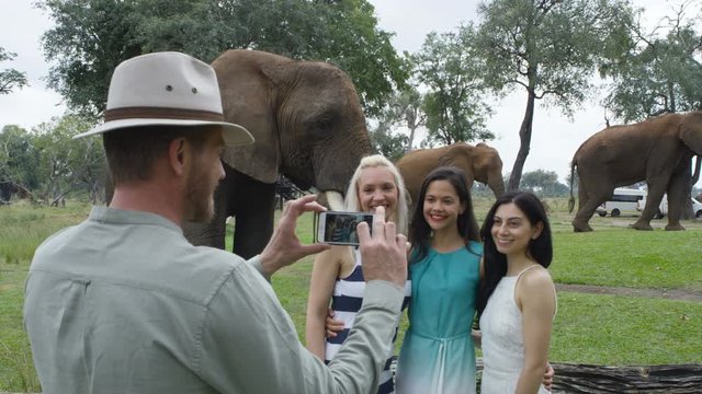  Friends on vacation in Africa pose for photo at a wild elephant nature reserv