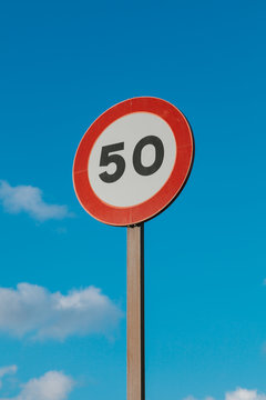 Round Speed Limit Road Sign Above Blue Sky