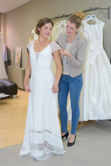 Naklejka premium Woman trying on wedding gown