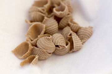 Uncooked organic fresh pasta on a light background.