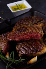 Grilled beef steak with spices on dark background