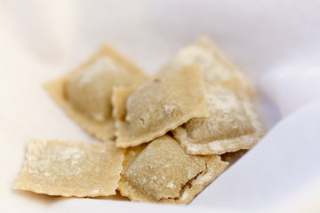 Uncooked organic fresh pasta on a light background.