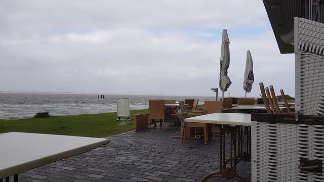 Emden Strand mir Strandkorb Tisch und St&uuml;hle bei schlechtem Wetter und wind